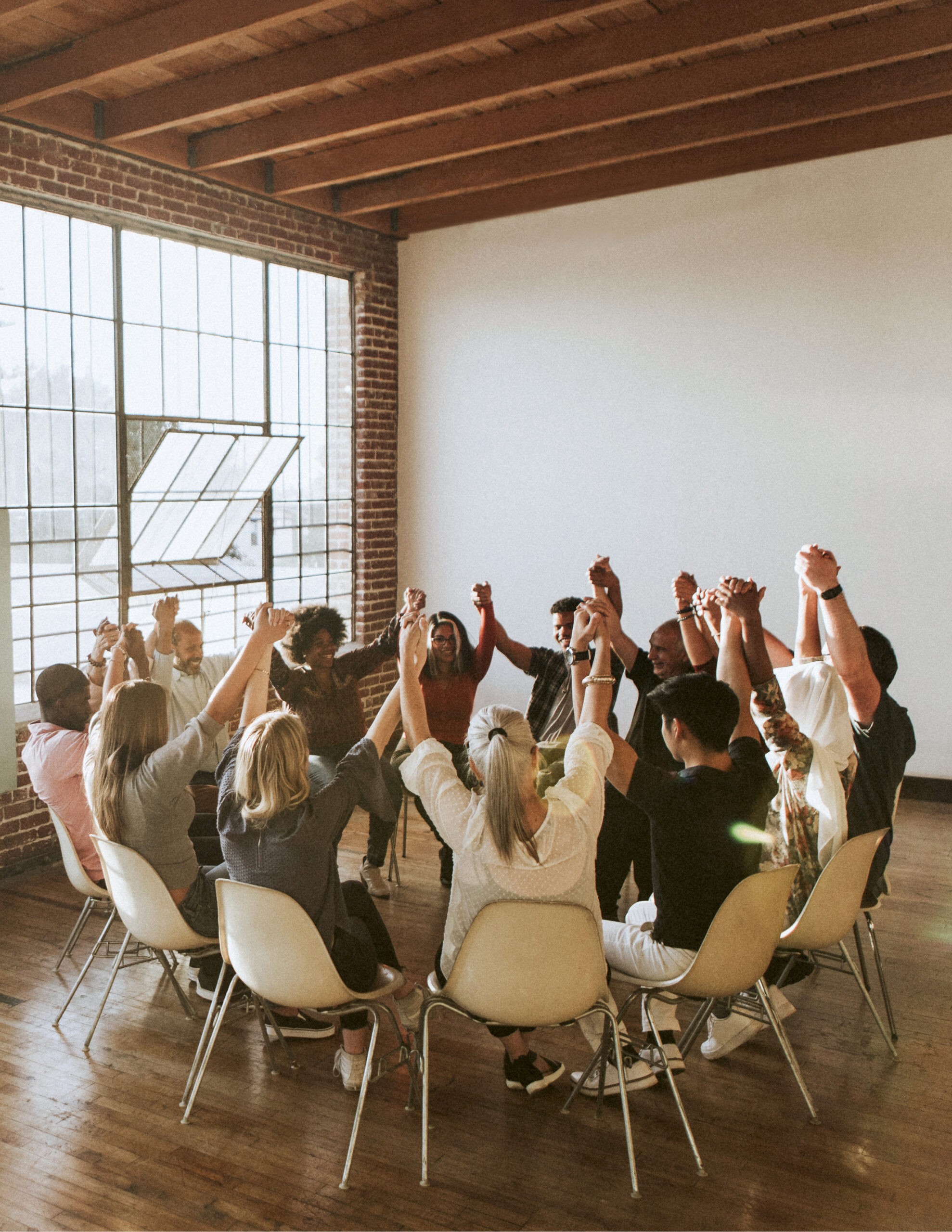 Group of diverse people holding hands up in the air